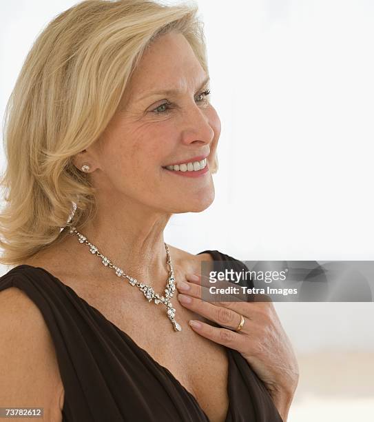 senior woman wearing diamond necklace - diamond necklace stock pictures, royalty-free photos & images