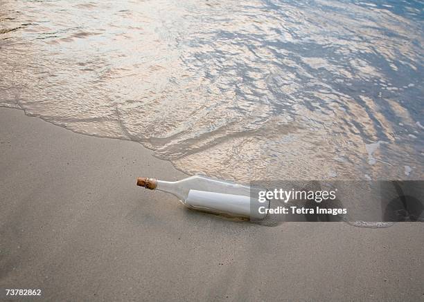 message in bottle on beach - flaschenpost stock-fotos und bilder