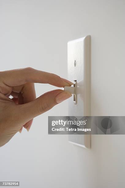 close up of woman turning light switch - switch off stock pictures, royalty-free photos & images