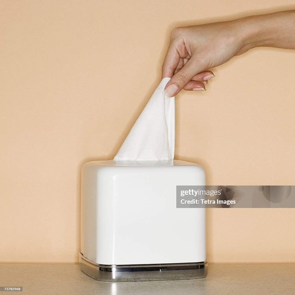 Woman pulling tissue out of box