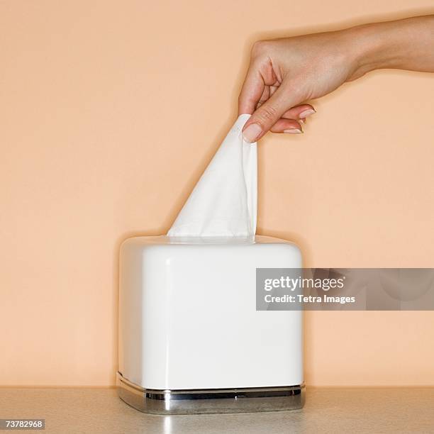 woman pulling tissue out of box - tissue box stock-fotos und bilder