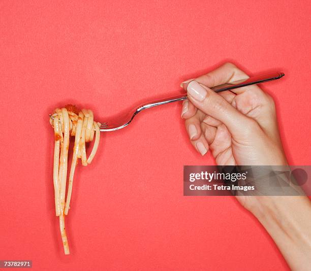 woman holding forkful of pasta - gaffel bildbanksfoton och bilder