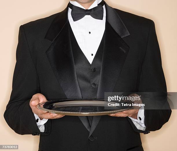 waiter in tuxedo holding silver platter - serving tray ストックフォトと画像