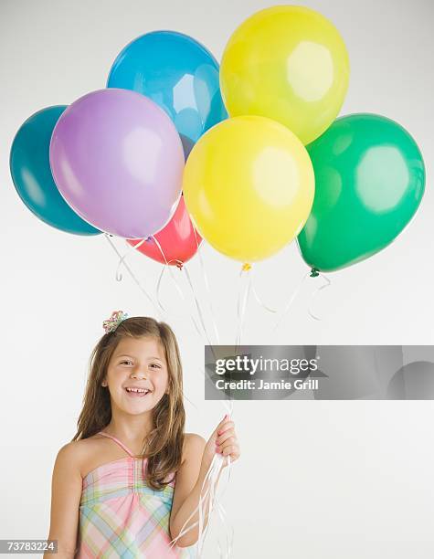 studio shot of girl holding bunch of balloons - child balloon studio photos et images de collection