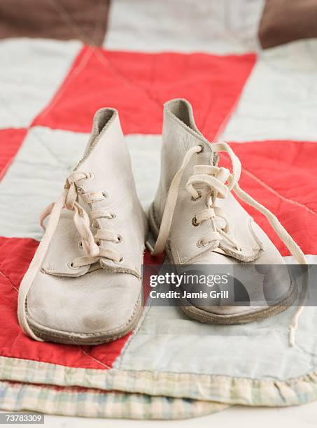 close up of old fashioned baby shoes on blanket - vintage baby shoes stock pictures, royalty-free photos & images