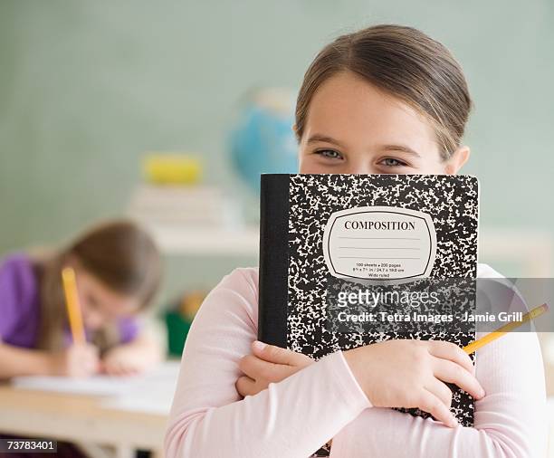 girl holding notebook in front of face - composition stock pictures, royalty-free photos & images