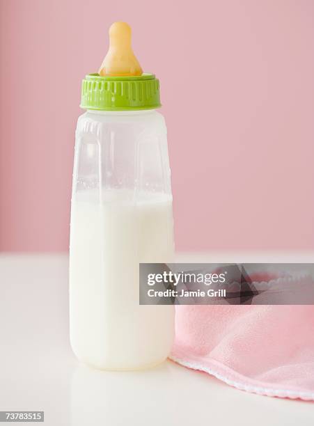 close up of baby bottle and bib - 哺乳瓶 ストックフォトと画像