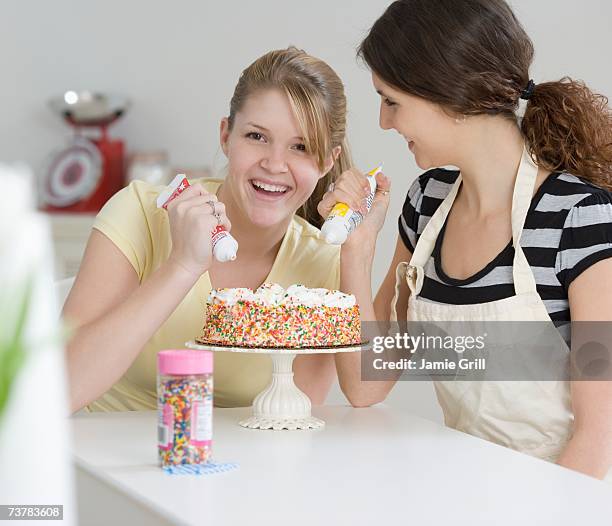 teenage girls decorating cake - young girls that squirt stock pictures, royalty-free photos & images