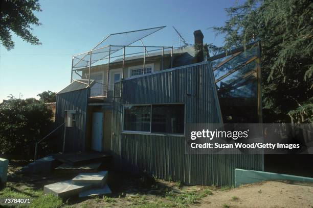 Exterior of Canadian-born American architect Frank Gehry's house, which he designed, showing the back steps, a corrugated iron wall, and a balcony...