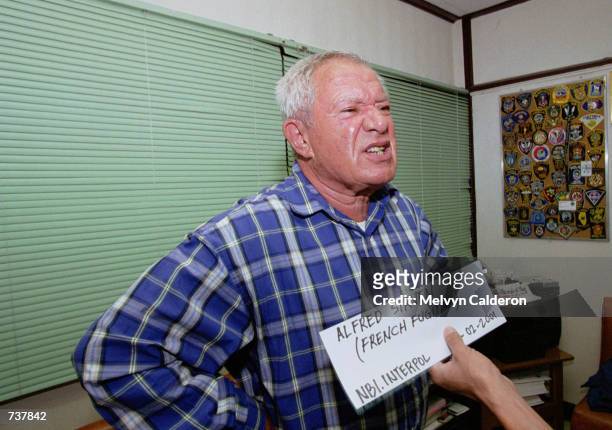 French fugitive businessman Alfred Sirven protests as his mug shot is taken by the arresting unit of the National Bureau of Investigation and...
