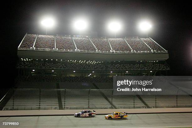 Scott Riggs driver of the Valvoline Dodge races with Dave Blaney driver of the Caterpillar Toyota during NASCAR Richmond Testing at Richmond...