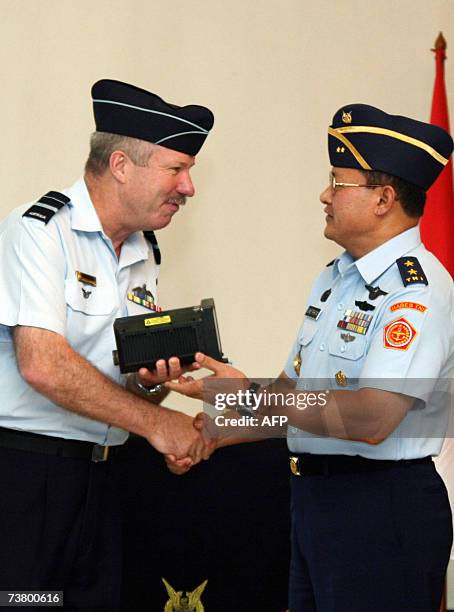 Royal Australian Air Force's Vice Marshall John Quaife and Indonesian Department of Defence representative, Air Marshal Slamet Prihatino shake hands...