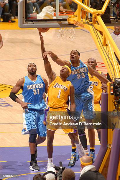 Smush Parker of the Los Angeles Lakers goes strong to the hoop against Marcus Camby and Nene of the Denver Nuggets on April 3, 2007 at Staples Center...