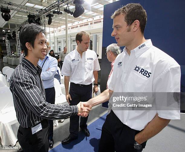 Alvin Koh of Singapore greets Williams F1 driver Alex Wurz of Austria after Koh took part in a simulated race during the RBS Grand Prix Challenge on...