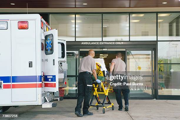 paramedics taking patient on stretcher from ambulance to hospital - serviço de urgência imagens e fotografias de stock