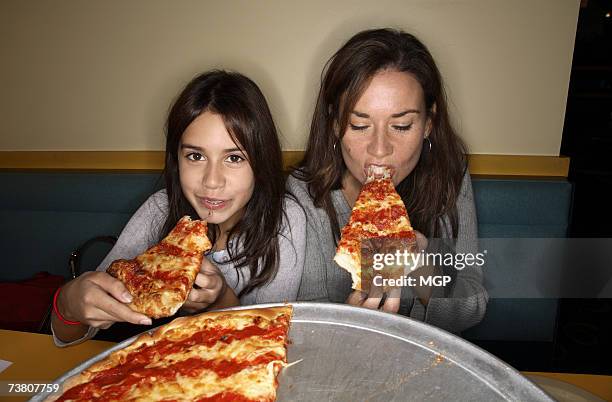 mother and daughter (11-13) eating pizza in restaurant booth,  portrait - comer pizza imagens e fotografias de stock