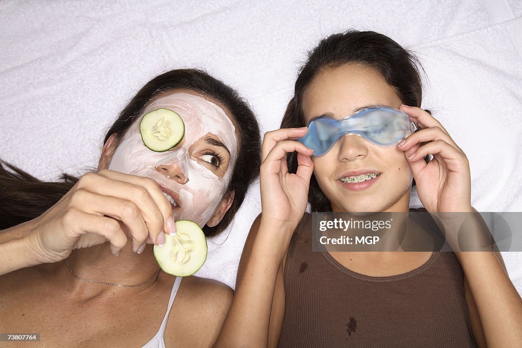 Mother and daughter (11-13) wearing face packs, close-up (overhead view)