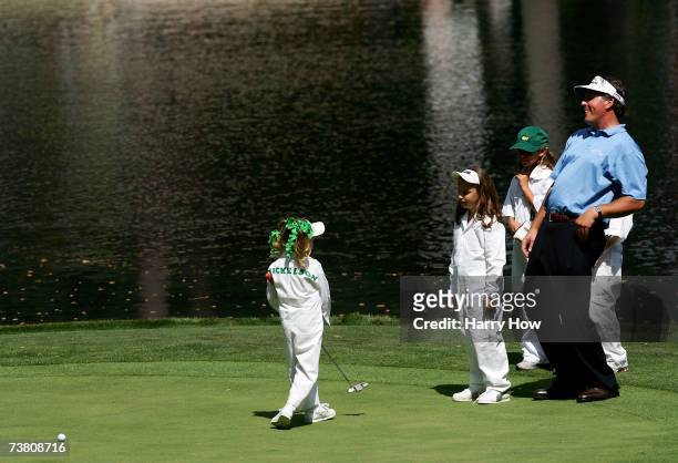 Phil Mickelson watches his daughter Amanda miss a putt on ninth green alongside his other Sophia during the Par-3 contest prior to the start of The...