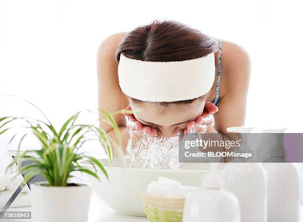 japanese woman washing her face with water of washbowl - waskom stockfoto's en -beelden