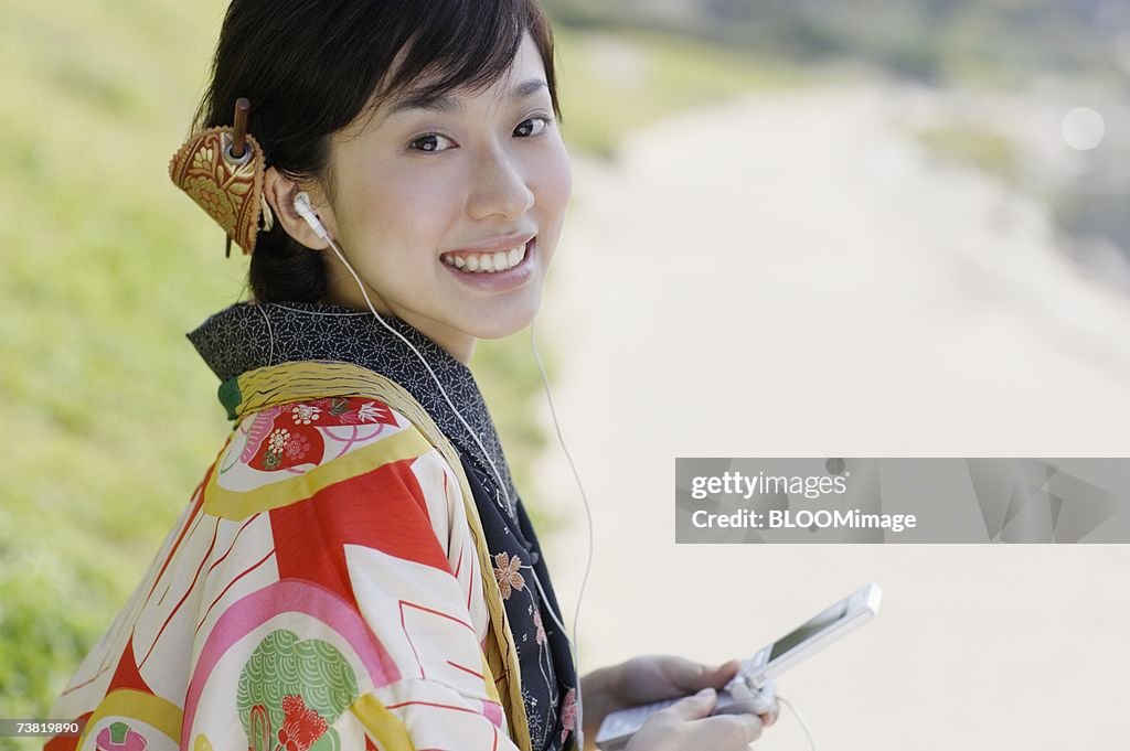 Woman wearing kimono with headphone