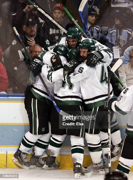 Jim McKenzie of the Michigan State Spartans and teammates Ethan Graham and Chris Mueller celebrate Mueller's goal against the Maine Blackbears during...