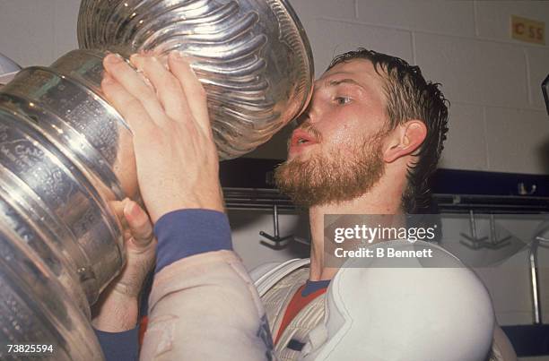 Canadian professional ice hockey player Gary Roberts of the Calgary Flames prepares to take a drink as he celebrates with the Stanley Cup award...