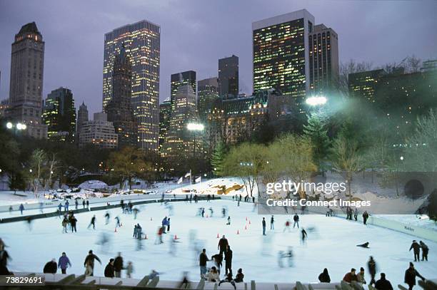 ice skating in central park by night - central park winter stock pictures, royalty-free photos & images