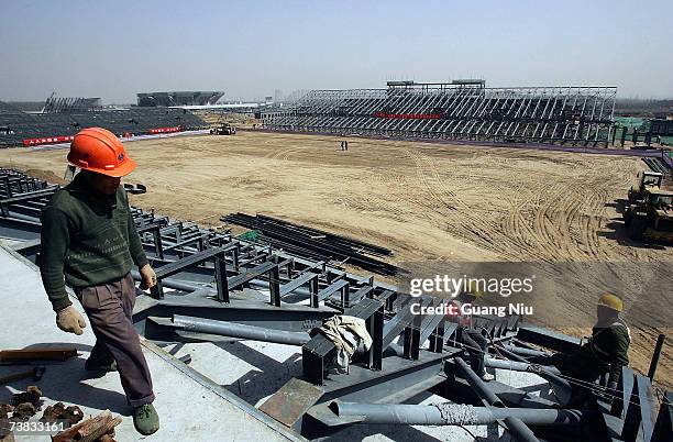 Chinese labourers work at the construction site of the Olympic Green Hockey Field on March 26, 2007 in Beijing, China. The Olympic Green Hockey Field...