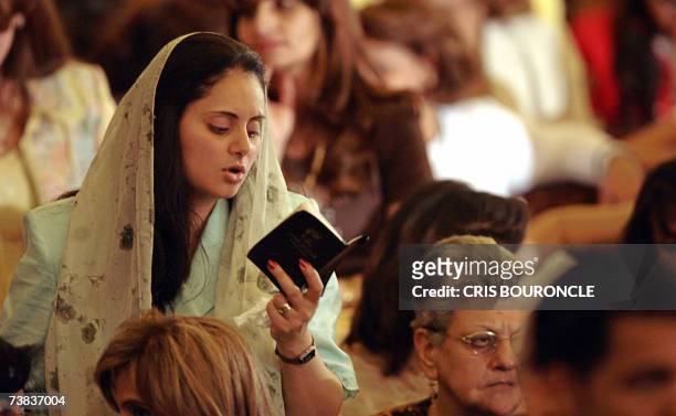 An Egyptian Copt woman follows the chanting of monks stands among the worshipers attending the Coptic Easter celebration mass directed by His...