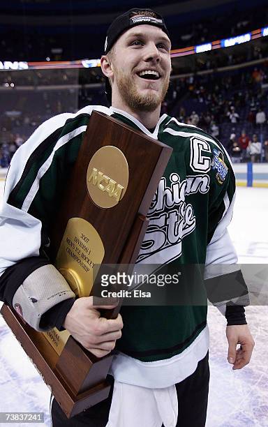 Chris Lawrence of the Michigan State Spartans holds the championship trophy after his team defeated the Boston College Eagles during the Frozen Four...