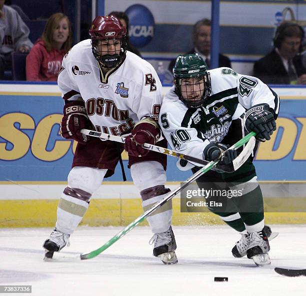 Tim Crowder of Michigan State Spartans tries to keep control of the puck as Nathan Gerbe of the Boston College Eagles fights for position during the...