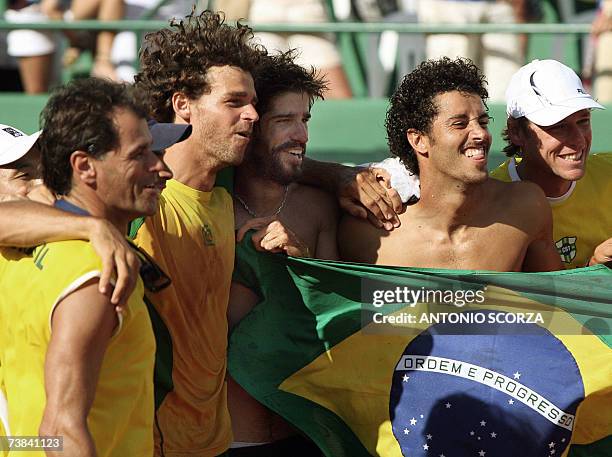 Florianopolis, BRAZIL: Brazilian tennis player Flavio Saretta and Gustavo Kuerten hold the national flag with other team members celebrating their...