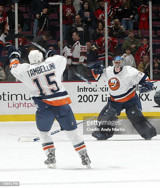 Winning goaltender Wade Dubielewicz and Jeff Tambellini of the New York Islanders celebrate the win in the shootout against the New Jersey Devils to...