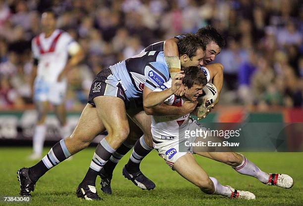 Josh Morris of the Dragons is tackled by Luke Douglas and Ben Ross of the Sharks during the round four NRL match between the Cronulla Sharks and the...