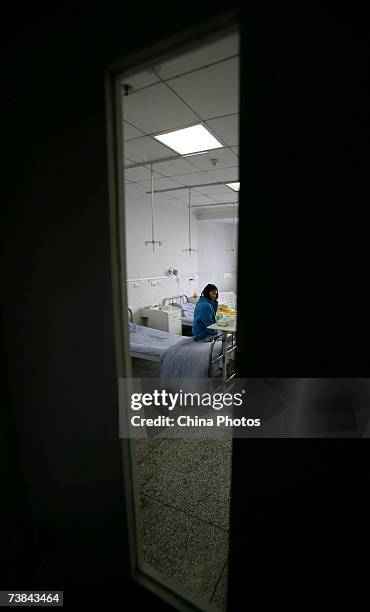 Chinese girl Li Yan, who suffers from face atrophy, sits on bed after doctors removed stitches on her face, at Chongqing Emergency Medical Center on...