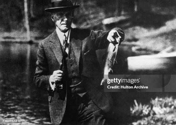 President Calvin Coolidge displays a catch during a fishing expedition, circa 1925.