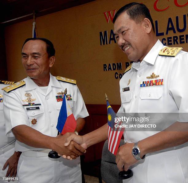 Philippine and Malaysian Fleet Commanders Petronilo P. Magno and Datu Mohd Amdan Bin Kurish shake hands during the opening ceremony of the...