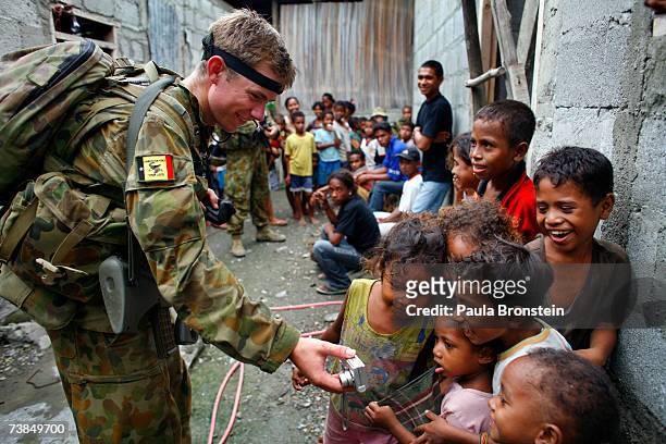 Australian peacekeeper Private Anthony shows a digital photo he shot to East Timorese children while on patrol, April 10, 2007 in Dili, East Timor....