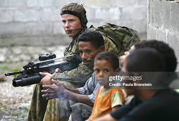 Australian peacekeeper Private Anthony sits with East Timorese while on patrol, resolving a dispute between gang members April 10, 2007 in Dili, East...