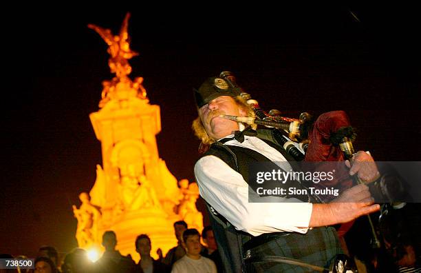 Scots piper David Hodge plays a highland lament at the announcement of the Queen Mother's death March 30, 2002 in front of the Queen Victoria...