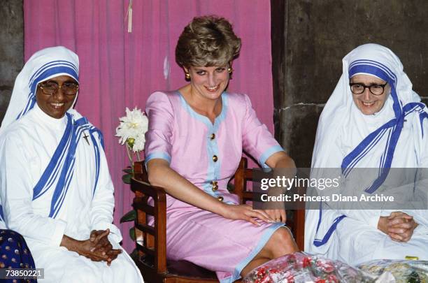 The Princess of Wales with two nuns during a visit to Mother Theresa's headquarters in Calcutta, India, 15th February 1992. Diana is wearing a dress...