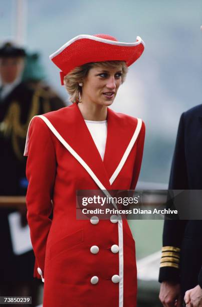 Princess Diana wearing a red Catherine Walker suit and Philip Somerville hat while attending a passing out parade at Dartmouth Royal Naval College in...