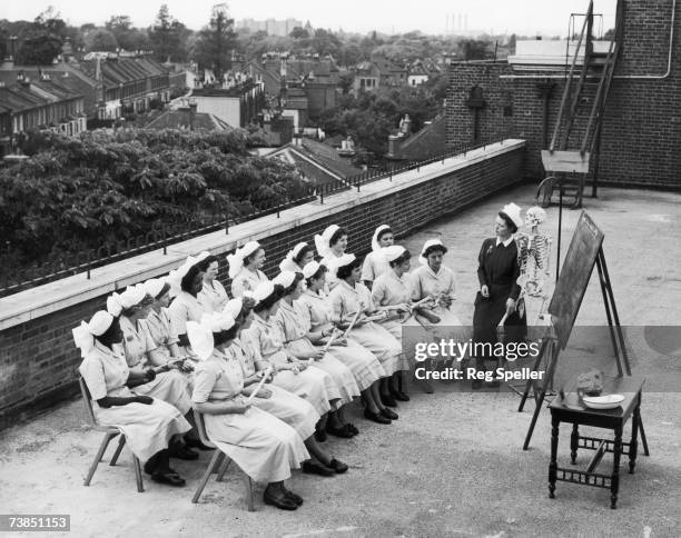 Tutor Margaret Young uses a skeleton to help her give an anatomy class to a group of student nurses on the roof of St. James' Hospital, Balham,...