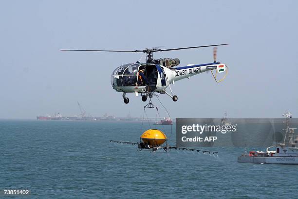 An Indian Coast Guard "Chetak "helicopter sprays oil dispersant from a Heli Task TC-3 during an exercise from ICG Ship Samar during a "Sagar...