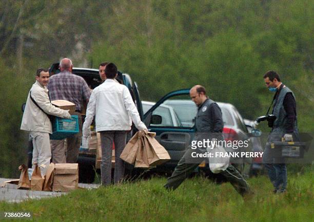 Des policiers discutent apres avoir releve des indices dans un bosquet proche du centre commercial d'Atlantis, le 11 Avril 2007 pres de Nantes, dans...