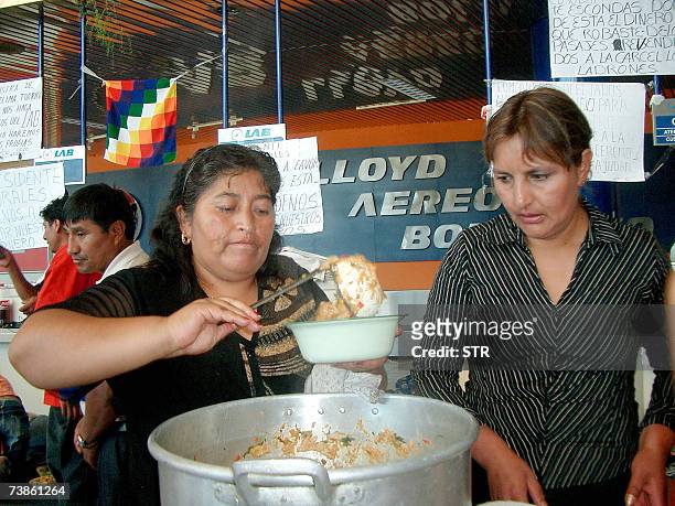 Pasajeros de la linea Lloyd Aereo Boliviano distribuyen comida cuando acampan en los mostradores de la compania en el aeropuerto de Cochabamba, el 11...