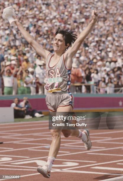 Joan Benoit of the United States raises her arms in celebration after winning the first ever Olympic Women's marathon event at the XXIII Olympic...