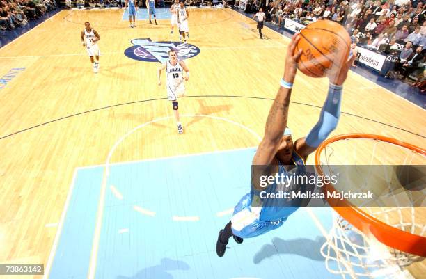 Carmelo Anthony of the Denver Nuggets beats Matt Harpring and the Utah Jazz down court for a dunk on April 11, 2007 at the EnergySolutions Arena in...