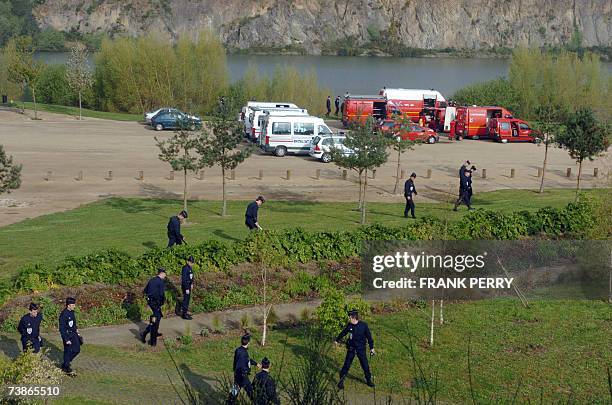 Saint-Herblain, FRANCE: Des policiers et des plongeurs fouillent un plan d'eau et ses environs situe a environ deux kilometres de la zone commerciale...