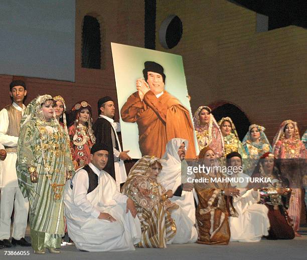 Tripoli, LIBYAN ARAB JAMAHIRIYA: Libyan theatrical group members hold a picture of leader Moamer Kadhafi during a musical play titled 'Tripoli's sun'...